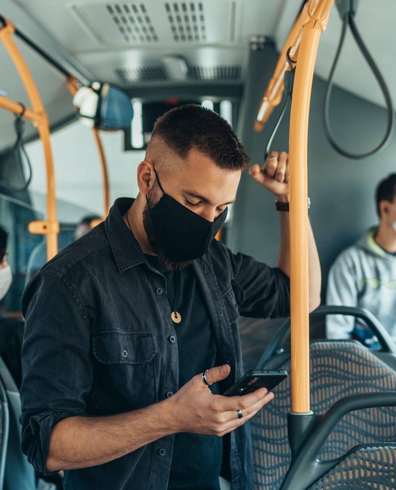 a man wearing a face mask on a bus